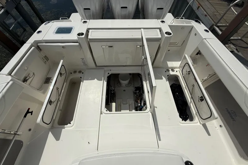 Slide: The Image of 2022 Pursuit S 378 Sport boat deck with open storage compartments and engine access. - 61