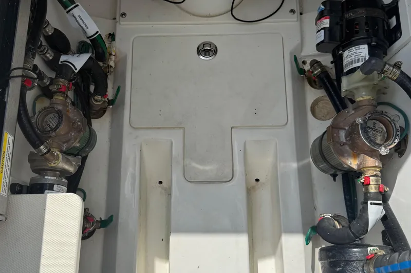 Slide: The Image of 2022 Pursuit S 378 Sport boat engine compartment with visible pumps and hoses. - 66