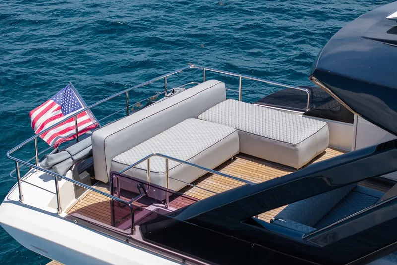 Slide: The Image of Luxurious 2022 Ferretti Yachts 670 with elegant deck seating and American flag, cruising on blue waters. - 22