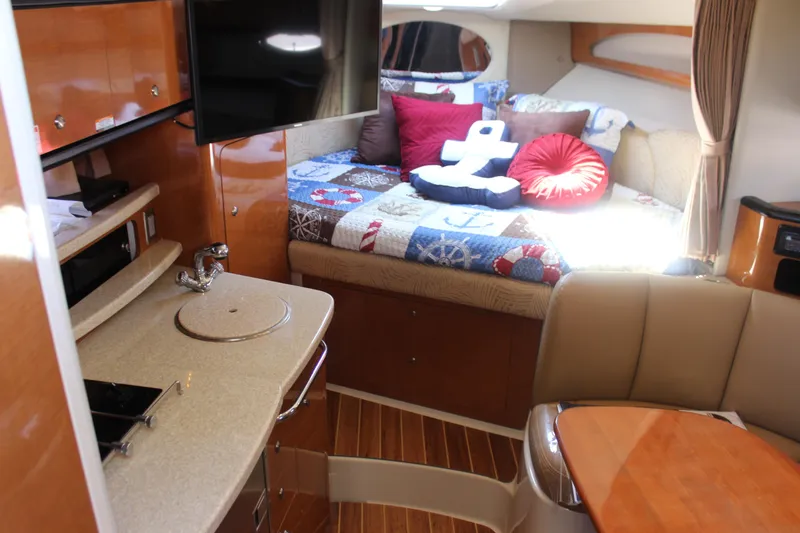 Slide: The Image of 2007 Chaparral Signature 310 interior with cozy bed, TV, and kitchenette. - 11