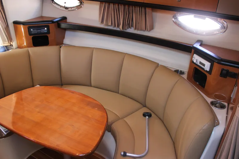 Slide: The Image of 2007 Chaparral Signature 310 cabin interior with curved seating and wooden table. - 14