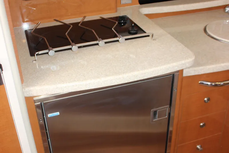 Slide: The Image of 2007 Chaparral Signature 310 yacht kitchen with stove and stainless steel fridge. - 21