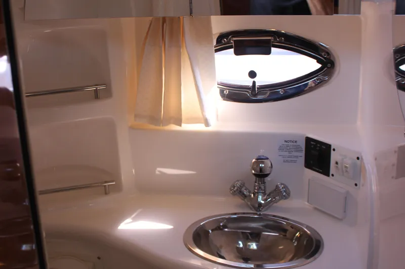 Slide: The Image of 2007 Chaparral Signature 310 boat bathroom with sink, window, and curtain. - 24