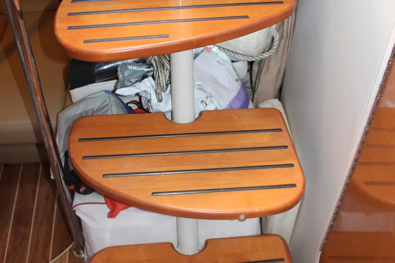 Slide: The Image of Wooden steps inside 2007 Chaparral Signature 310 boat, with storage items underneath. - 26