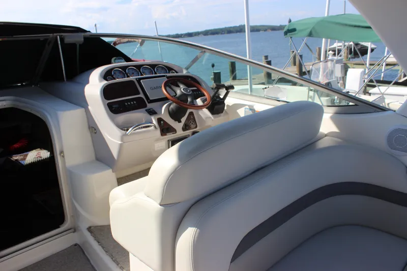 Slide: The Image of 2007 Chaparral Signature 310 boat cockpit with steering wheel and dashboard, docked by the water. - 29