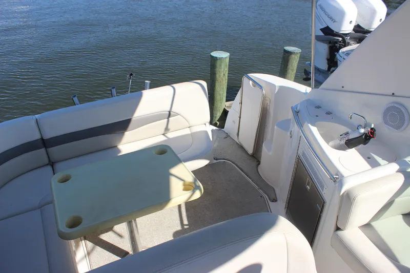 Slide: The Image of 2007 Chaparral Signature 310 boat interior with seating, table, and sink by the water. - 34