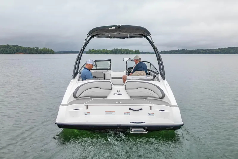 Slide: The Image of 2023 Yamaha Boats AR190 on a calm lake with two passengers. - 2
