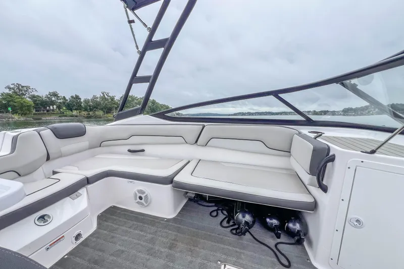 Slide: The Image of 2023 Yamaha Boats AR190 interior with spacious seating and sleek design on a calm water backdrop. - 23