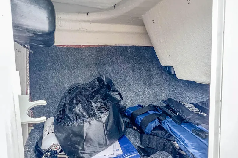 Slide: The Image of Storage compartment in 2023 Yamaha AR190 boat with life jackets and gear. - 24