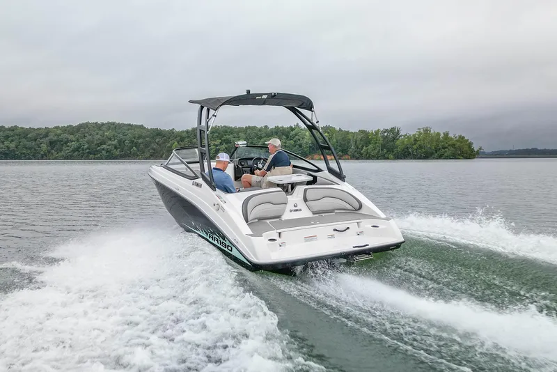 Slide: The Image of 2023 Yamaha Boats AR190 cruising on a lake with two passengers onboard. - 3