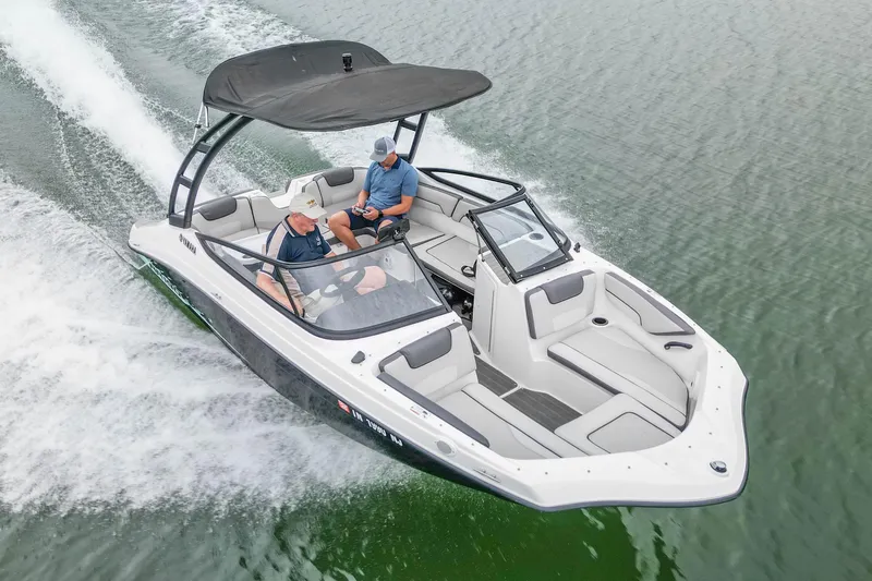 Slide: The Image of 2023 Yamaha Boats AR190 cruising on water with two passengers, featuring sleek design and canopy. - 6