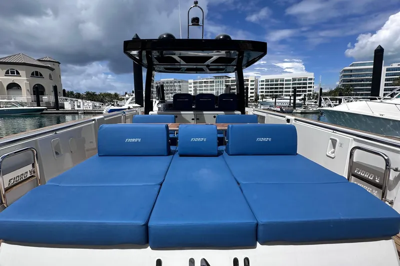 Slide: The Image of 2020 Fjord 44 Open yacht with blue sunbeds, docked at a marina. - 11