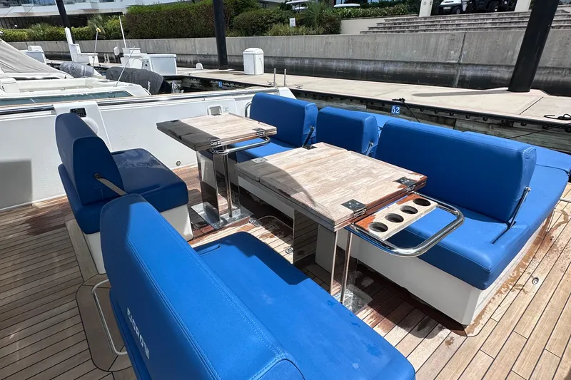 Slide: The Image of 2020 Fjord 44 Open yacht with blue seating and wooden deck, docked at marina. - 14