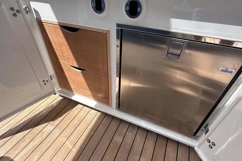 Slide: The Image of Interior of 2020 Fjord 44 Open yacht with wooden drawers and stainless steel fridge. - 21