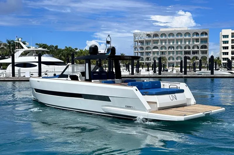 Slide: The Image of 2020 Fjord 44 Open yacht docked in a marina with modern buildings in the background. - 7