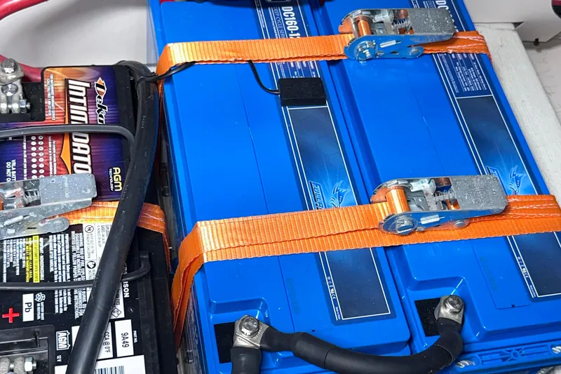 Slide: The Image of Battery setup in a 2020 Fjord 44 Open boat, featuring secured blue and black batteries. - 70