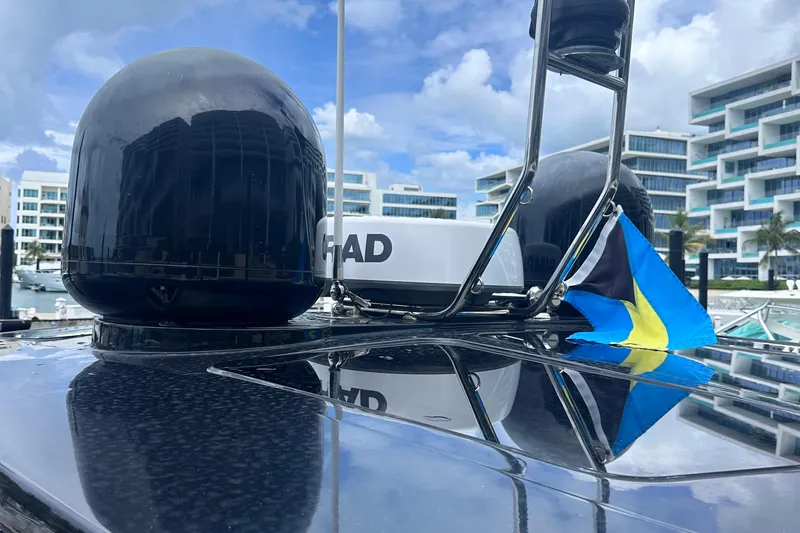 Slide: The Image of 2020 Fjord 44 Open yacht with radar and flag, docked near modern buildings. - 76