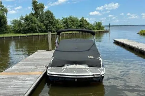 Slide: The Image of 2014 Larson LXi 258 IO boat docked on a sunny day by a lake. - 4