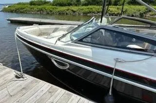 Slide: The Image of 2014 Larson LXi 258 IO boat docked by a wooden pier. - 6