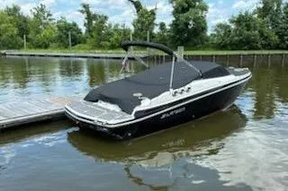 Slide: The Image of 2014 Larson LXi 258 IO boat docked on calm water, covered and ready for use. - 7