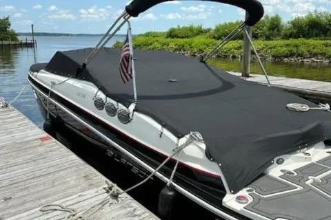 Slide: The Image of 2014 Larson LXi 258 IO boat docked with black cover and American flag. - 8