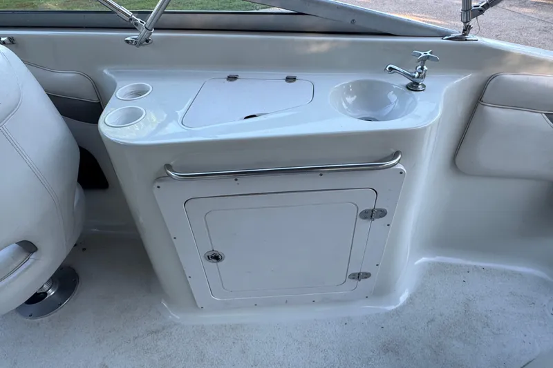 Slide: The Image of 2002 Crownline 239 DB boat interior with cushioned seating by the water. - 13