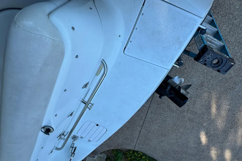 Slide: The Image of 2002 Crownline 239 DB boat interior with seating, canopy, and steering wheel on a calm lake. - 15