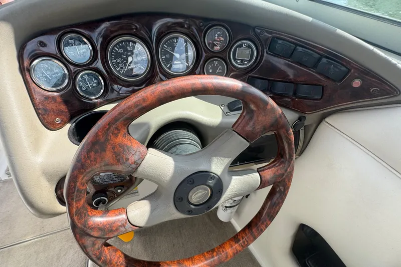 Slide: The Image of Steering wheel and dashboard of 2002 Crownline 239 DB boat with wood accents. - 17