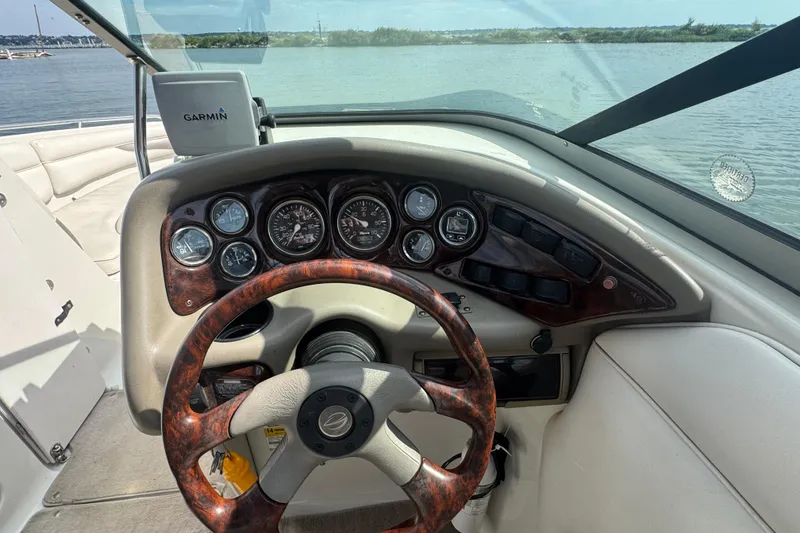 Slide: The Image of 2002 Crownline 239 DB boat dashboard with steering wheel and Garmin GPS on a sunny day. - 18
