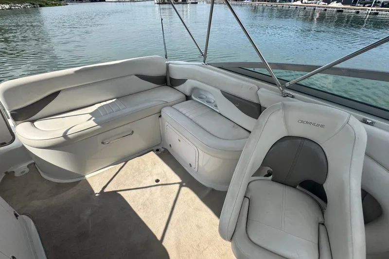 Slide: The Image of 2002 Crownline 239 DB boat interior with white seating and lake view. - 20