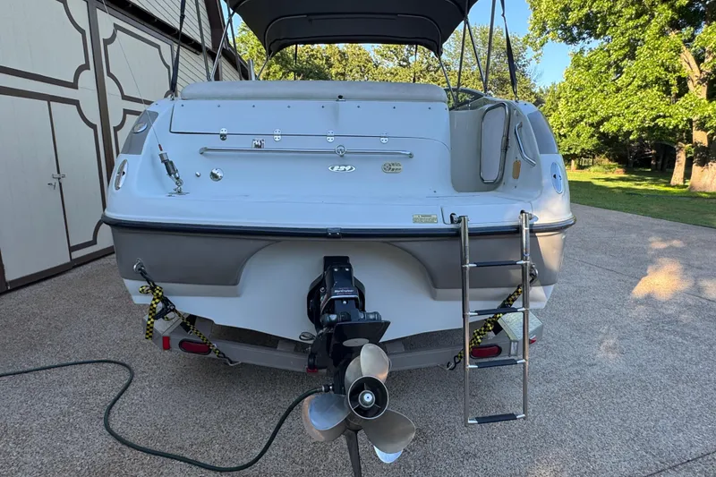Slide: The Image of 2002 Crownline 239 DB boat cruising on a calm lake under a clear sky. - 4