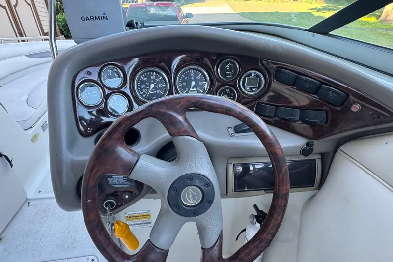 Slide: The Image of 2002 Crownline 239 DB boat rear view with ladder and propeller, parked outdoors. - 9