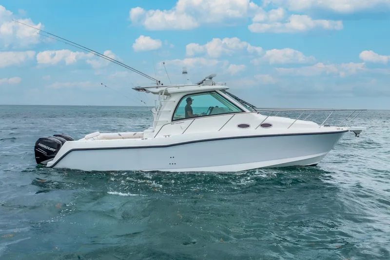 Slide: The Image of 2012 Boston Whaler 345 Conquest boat cruising on open water under a blue sky. - 13