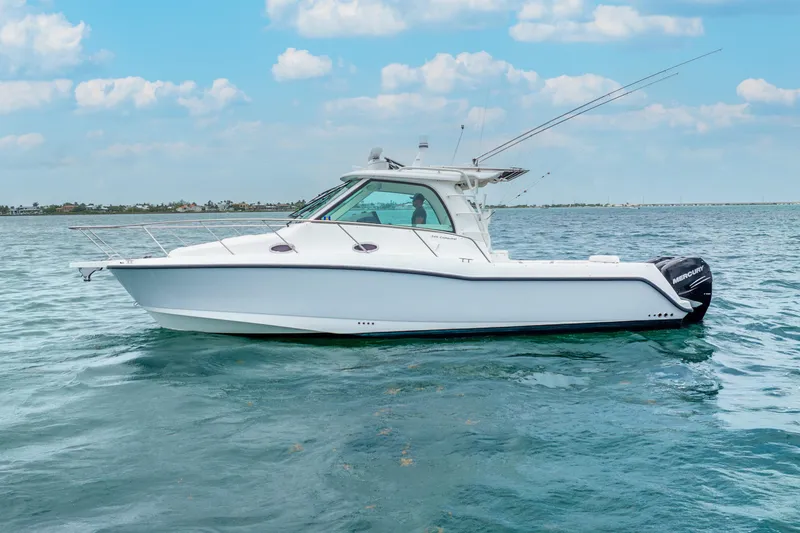Slide: The Image of 2012 Boston Whaler 345 Conquest boat on calm water under blue sky. - 15