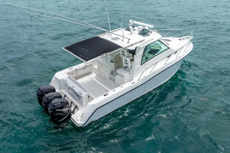 Slide: The Image of 2012 Boston Whaler 345 Conquest boat on open water, featuring triple Mercury engines. - 22