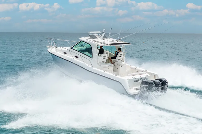 Slide: The Image of 2012 Boston Whaler 345 Conquest cruising on open water, creating a dynamic wake. - 24