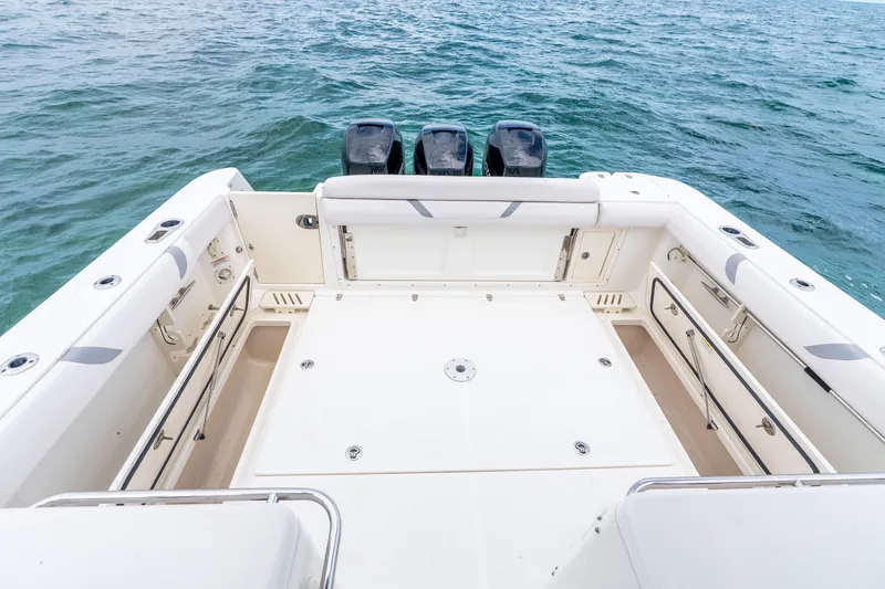 Slide: The Image of 2012 Boston Whaler 345 Conquest boat deck with triple outboard motors on open sea. - 35
