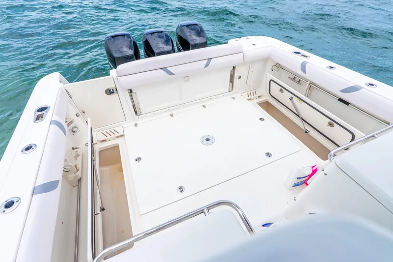 Slide: The Image of 2012 Boston Whaler 345 Conquest boat deck with triple outboard motors on the water. - 36
