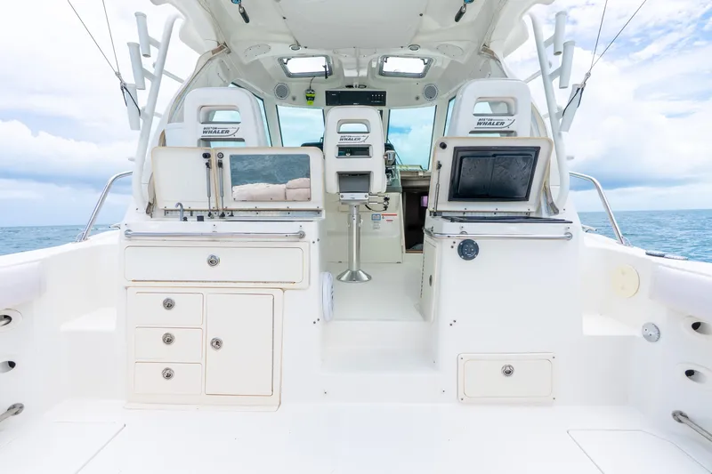 Slide: The Image of 2012 Boston Whaler 345 Conquest boat interior with ocean view, featuring helm and seating area. - 40
