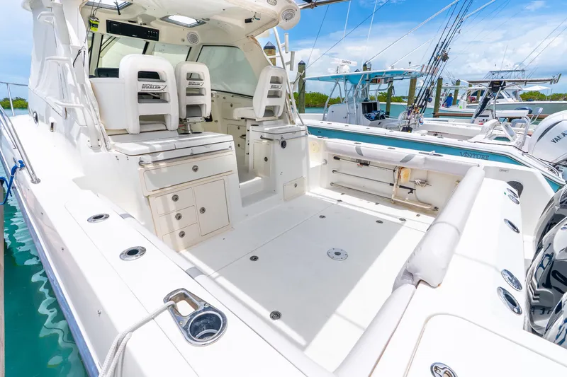 Slide: The Image of 2012 Boston Whaler 345 Conquest boat interior with seating and storage, docked in a marina. - 42