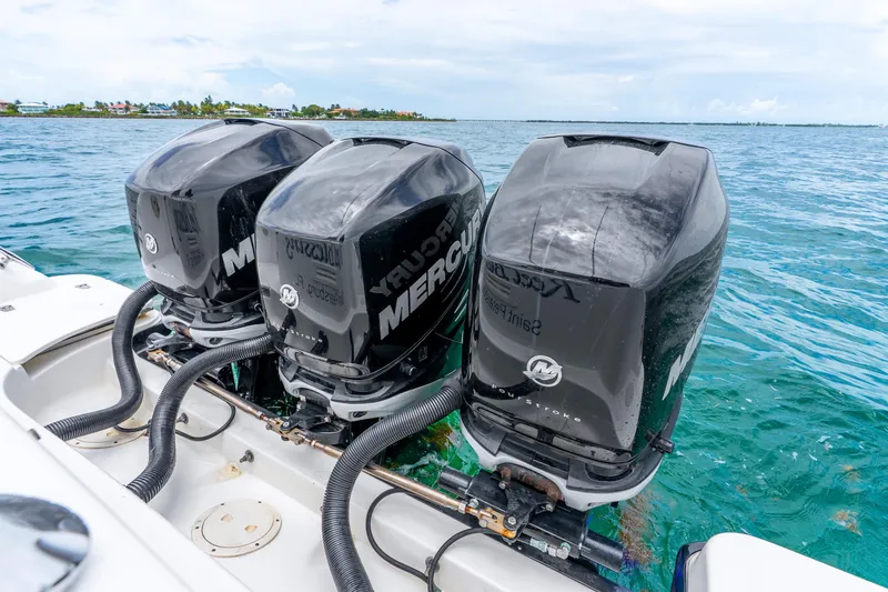 Slide: The Image of Triple Mercury outboard engines on a 2012 Boston Whaler 345 Conquest in clear blue waters. - 43