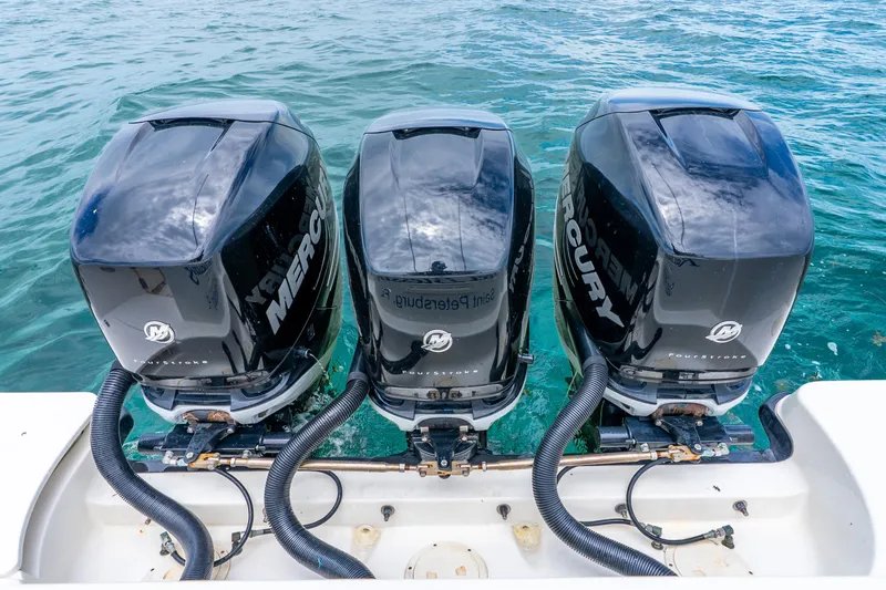 Slide: The Image of Triple Mercury outboard engines on a 2012 Boston Whaler 345 Conquest in clear blue water. - 44