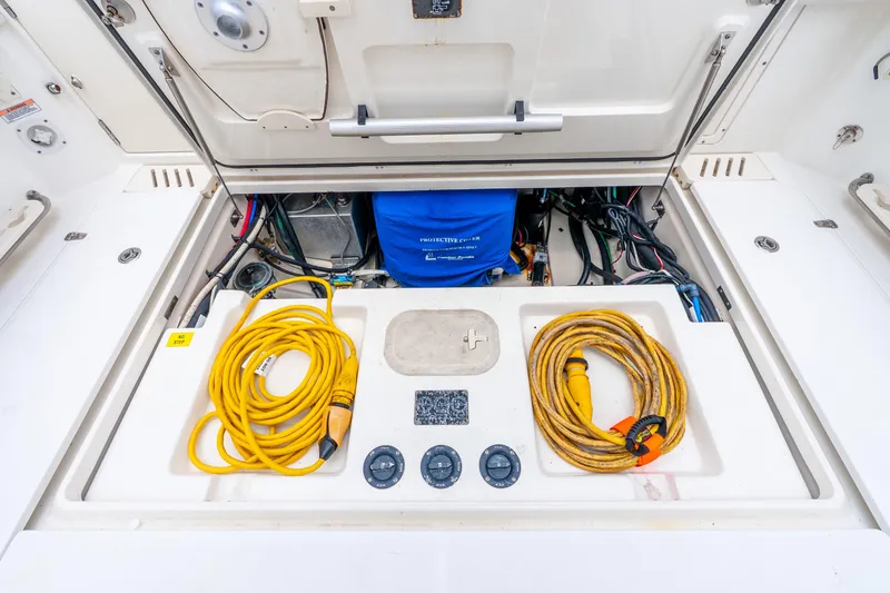 Slide: The Image of 2012 Boston Whaler 345 Conquest engine compartment with cables and equipment. - 56