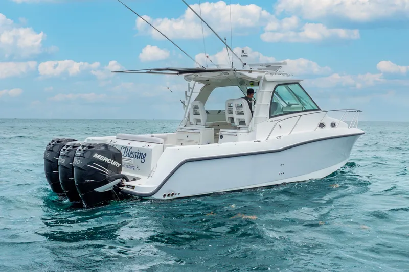 Slide: The Image of 2012 Boston Whaler 345 Conquest boat on open water, featuring triple Mercury engines. - 7