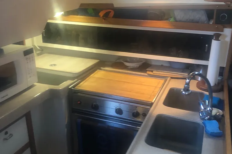Slide: The Image of Compact kitchen in a 1996 Catalina 30 MkIII sailboat with stove, sink, and microwave. - 14