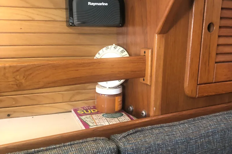 Slide: The Image of 1996 Catalina 30 MkIII interior with wood paneling, Raymarine device, and Sudoku book. - 16