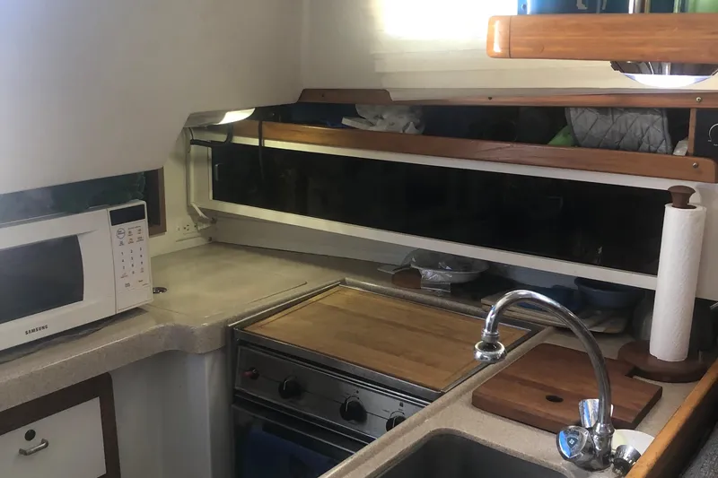 Slide: The Image of Compact kitchen in a 1996 Catalina 30 MkIII sailboat with microwave, stove, and sink. - 37