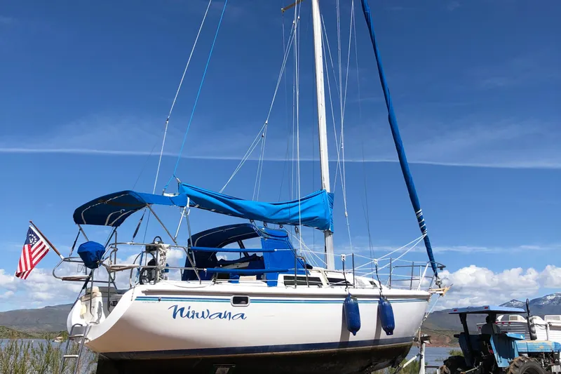 Slide: The Image of Sailboat Catalina 30 MkIII 1996 with blue sails and American flag, docked under clear sky. - 39