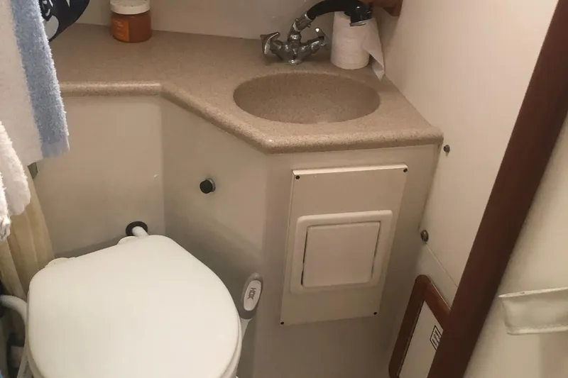 Slide: The Image of Compact bathroom in a 1996 Catalina 30 MkIII sailboat, featuring a sink and toilet. - 46
