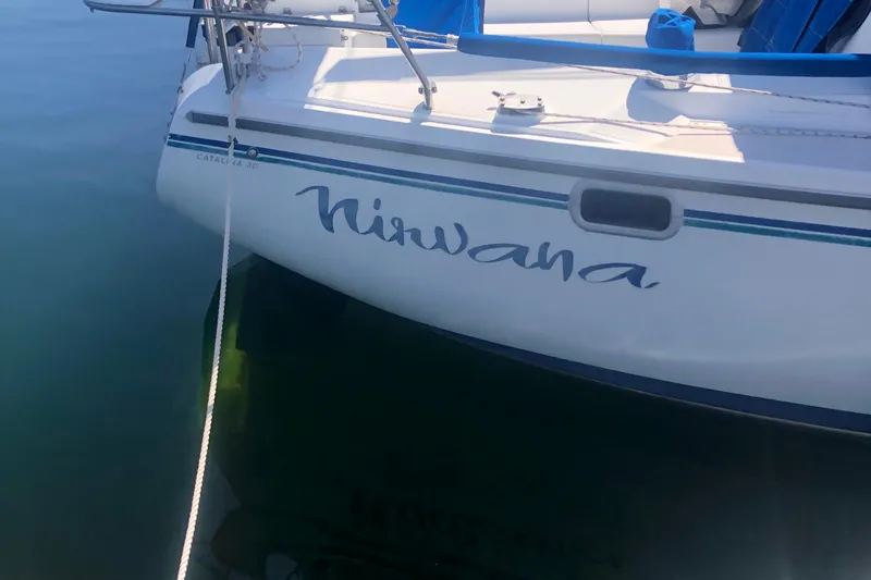 Slide: The Image of Catalina 30 MkIII sailboat named "Nirvana" docked on calm water, 1996 model. - 50